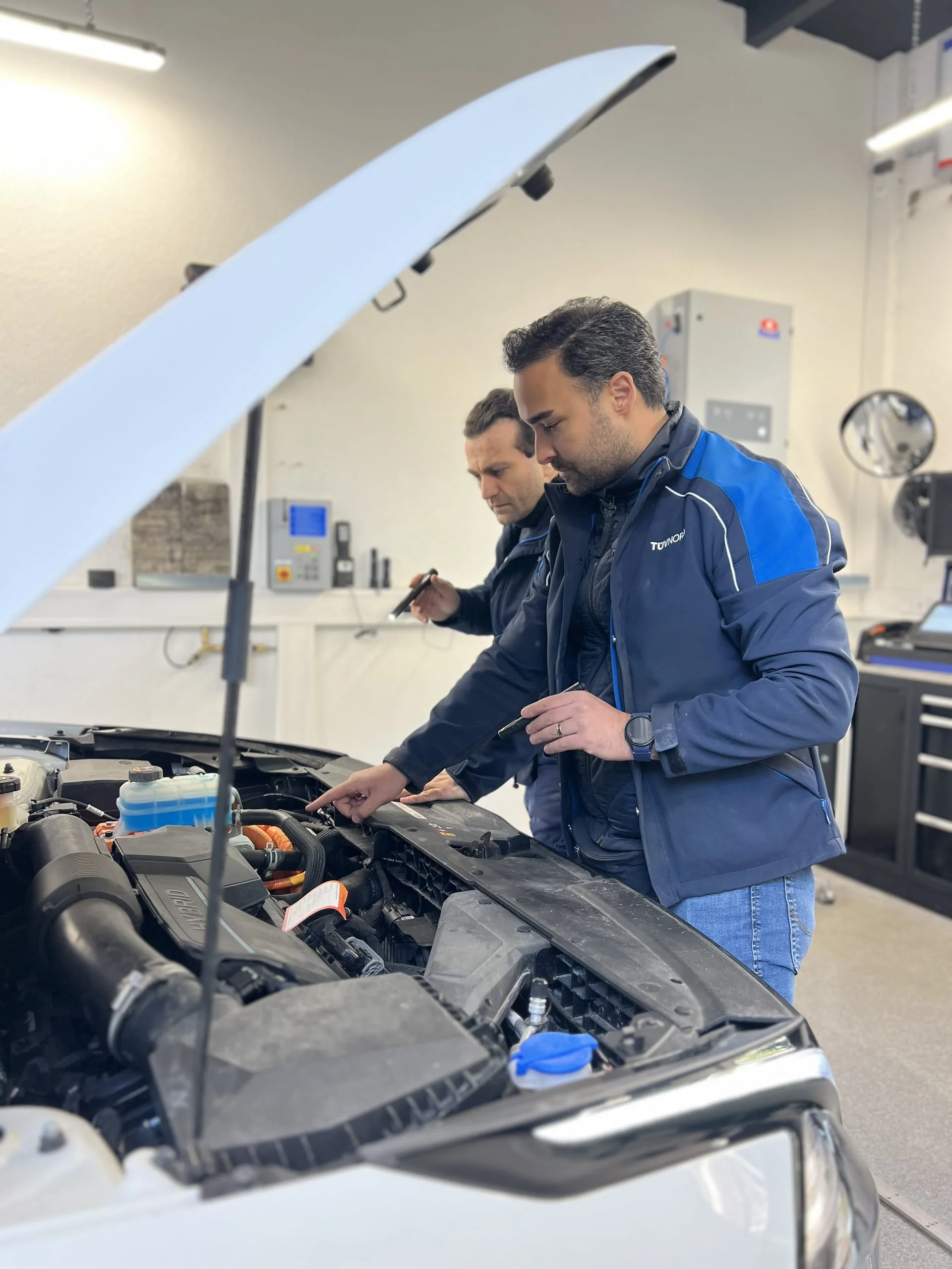 TÜV-Prüfingenieure bei der Motorprüfung